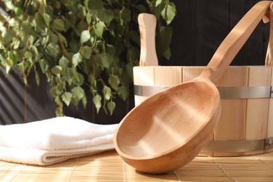 Sauna equipment. Bucket, ladle and towel on bamboo bench