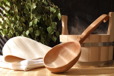 Sauna equipment. Bucket, ladle, felt wool hat and towel on bamboo bench