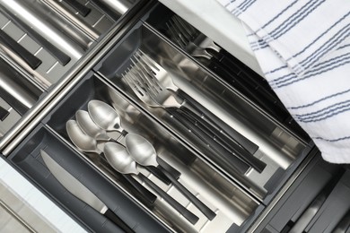 Photo of Box with cutlery in drawer, top view. Kitchen utensils storage