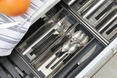 Photo of Box with cutlery in drawer, top view. Kitchen utensils storage