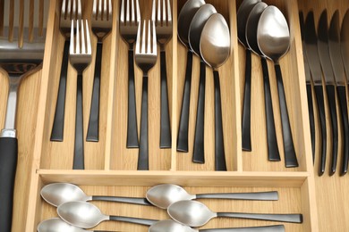 Photo of Box with cutlery in drawer, above view. Kitchen utensils storage