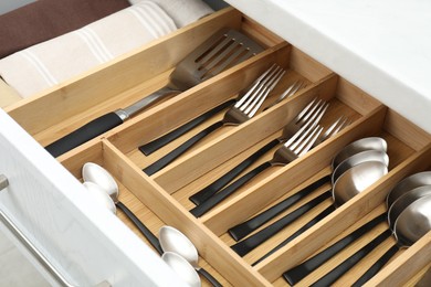 Photo of Box with cutlery in drawer, closeup. Kitchen utensils storage