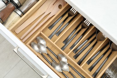 Photo of Box with cutlery in drawer, above view. Kitchen utensils storage