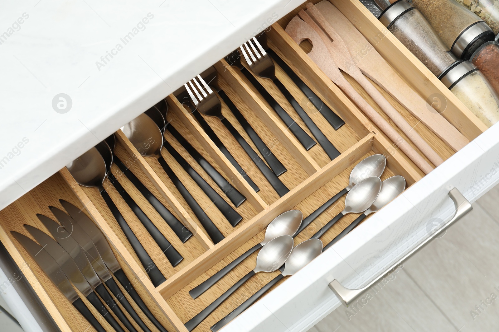 Photo of Box with cutlery in drawer, above view. Kitchen utensils storage