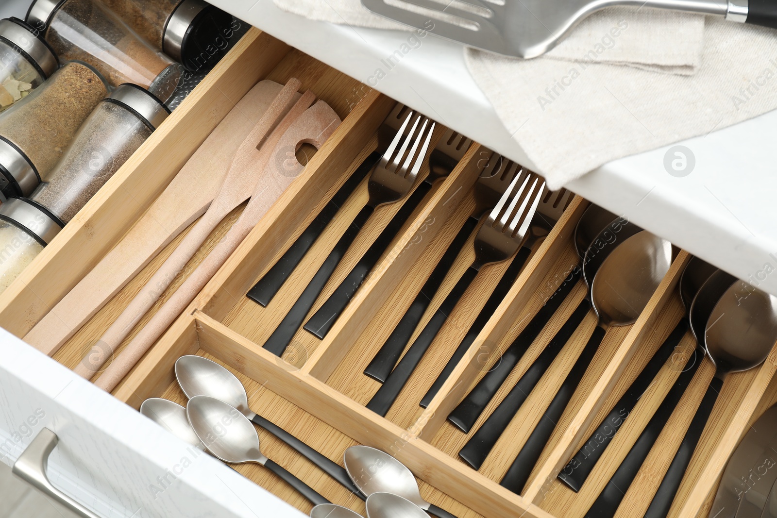 Photo of Box with cutlery in drawer, above view. Kitchen utensils storage