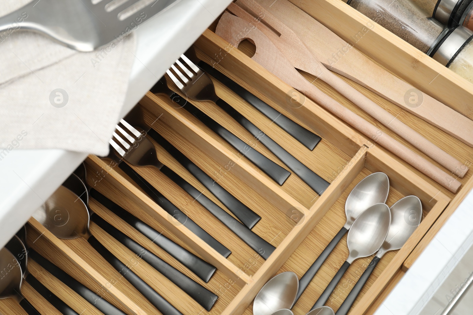 Photo of Box with cutlery in drawer, above view. Kitchen utensils storage