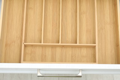 Photo of Open drawer of kitchen cabinet with space for cutlery, above view