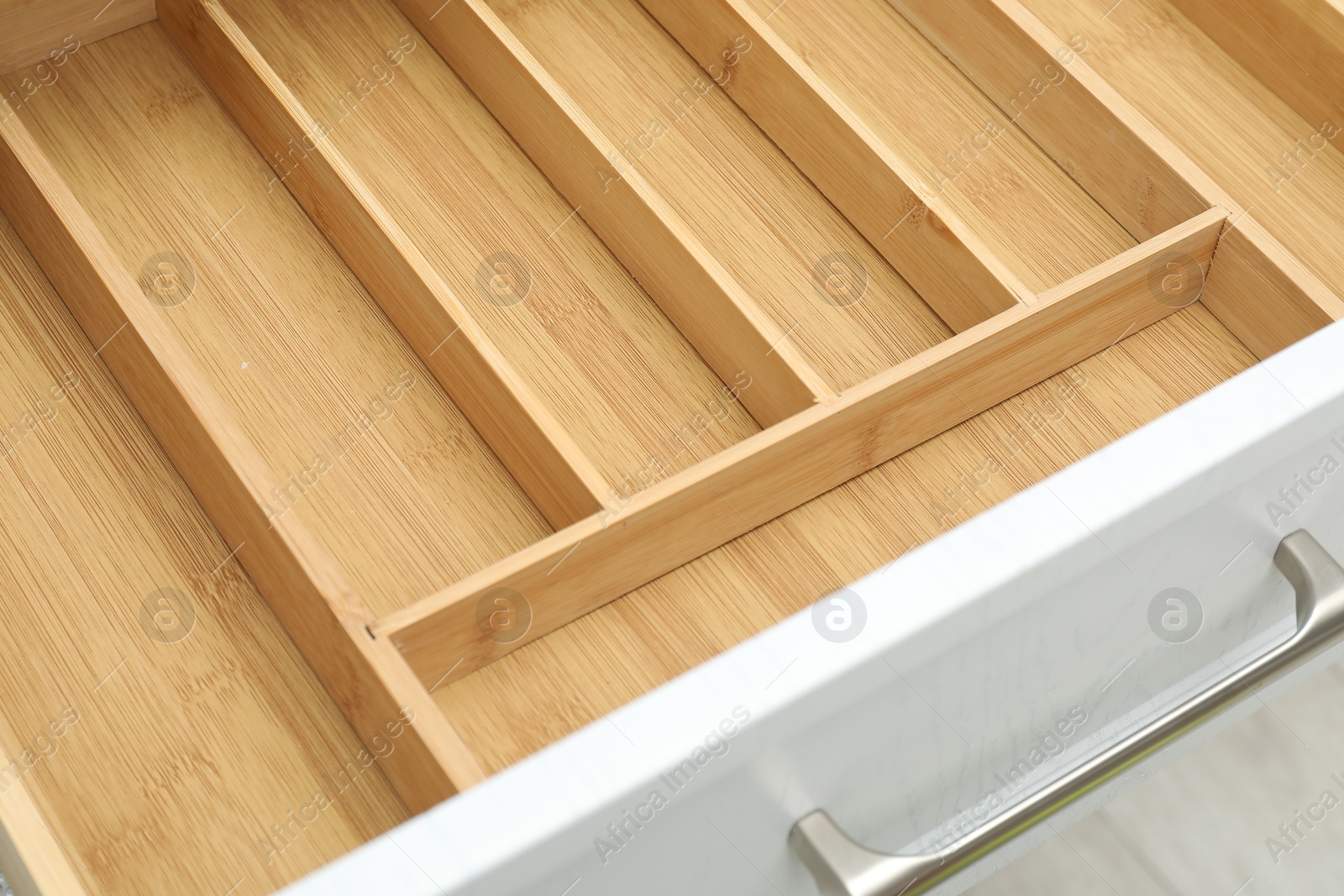 Photo of Open drawer of kitchen cabinet with space for cutlery, closeup