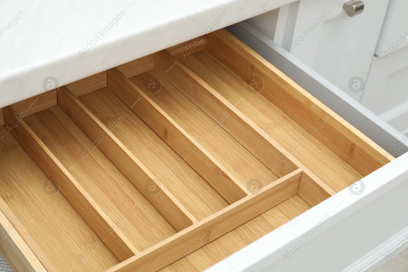 Photo of Open drawer of kitchen cabinet with space for cutlery, closeup