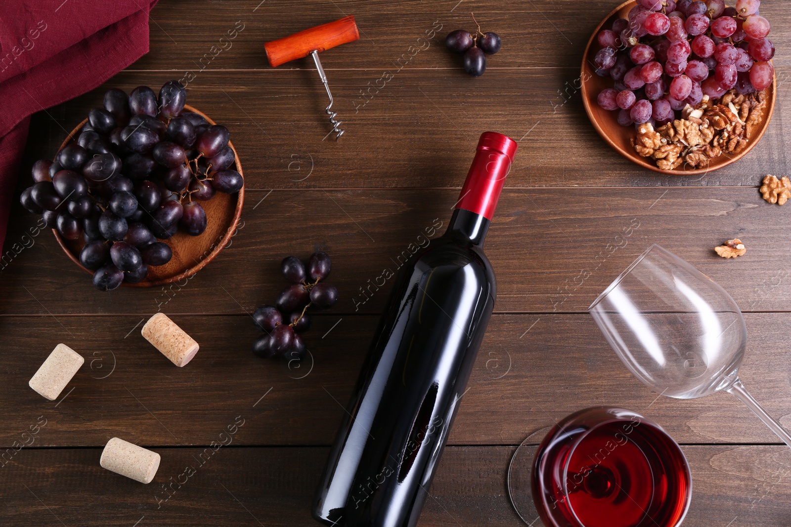 Photo of Flat lay composition with corkscrew and red wine on wooden table