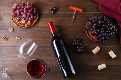 Flat lay composition with corkscrew and red wine on wooden table