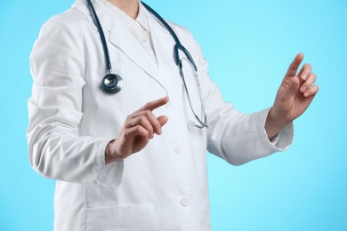 Photo of Doctor holding something on light blue background, closeup