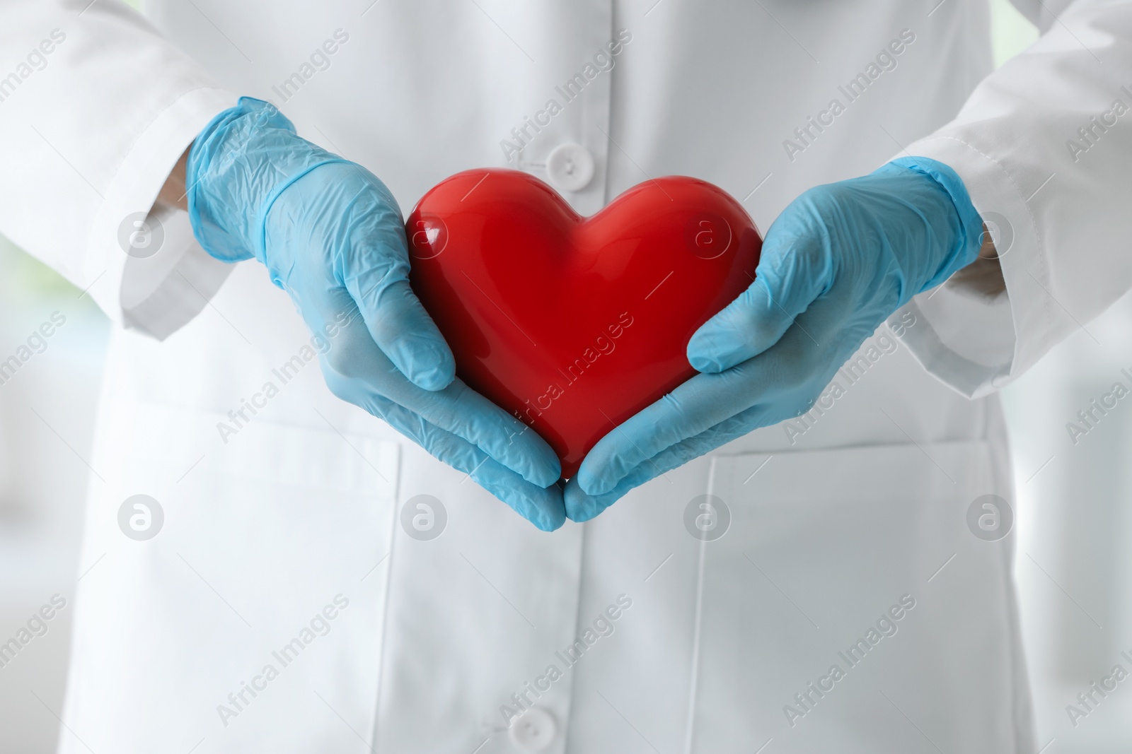 Photo of Doctor with red heart in clinic, closeup