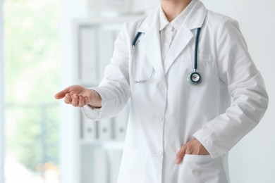 Doctor with stethoscope holding something in clinic, closeup