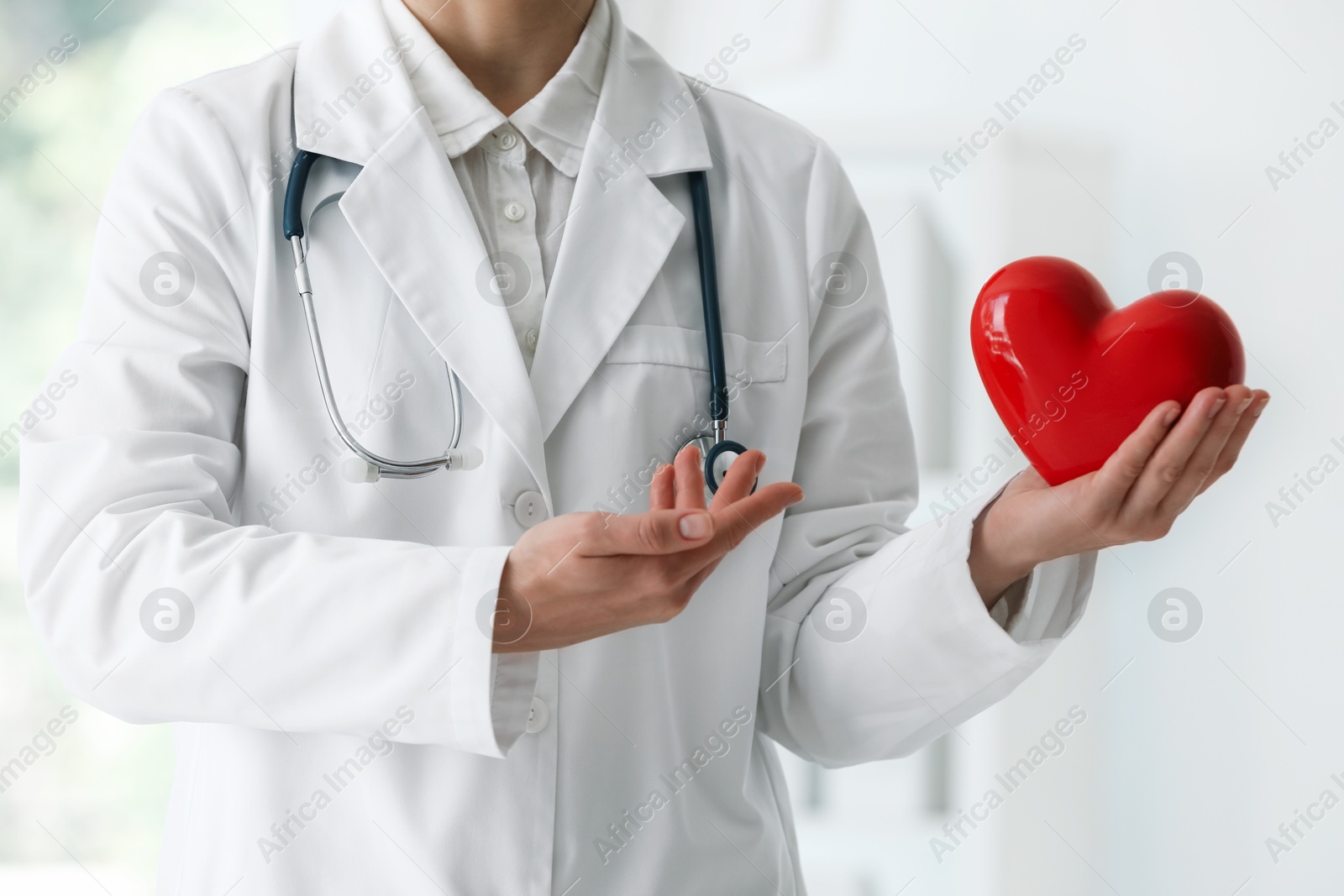 Photo of Doctor with red heart in clinic, closeup