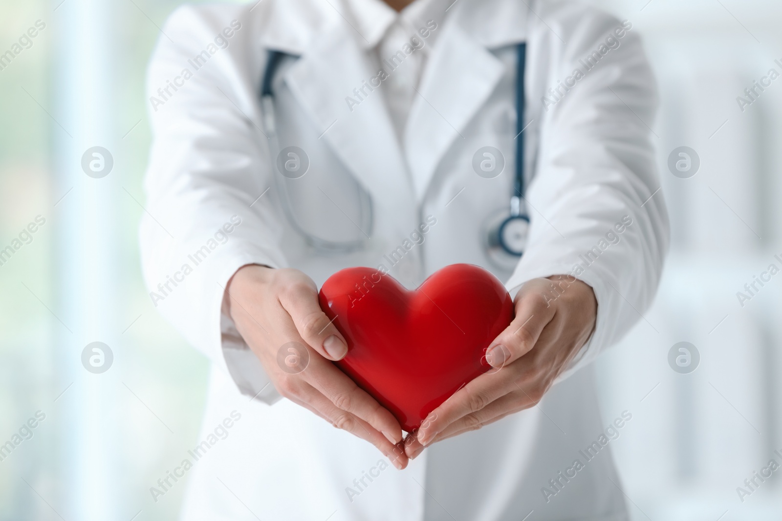 Photo of Doctor with red heart in clinic, closeup