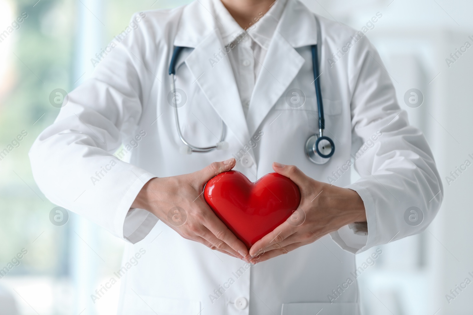 Photo of Doctor with red heart in clinic, closeup