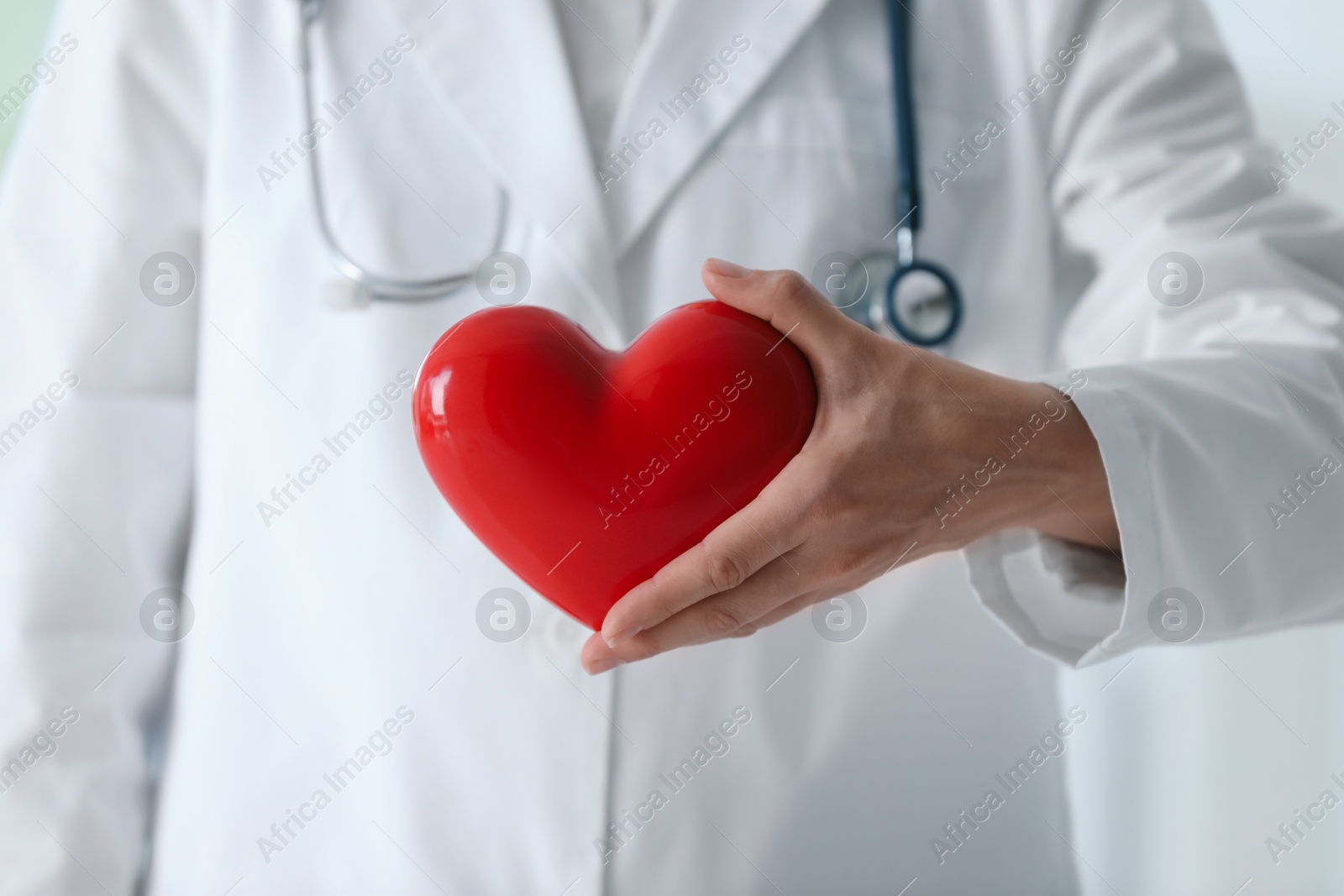 Photo of Doctor with red heart in clinic, closeup