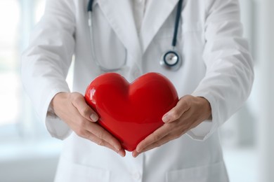 Doctor with red heart in clinic, closeup