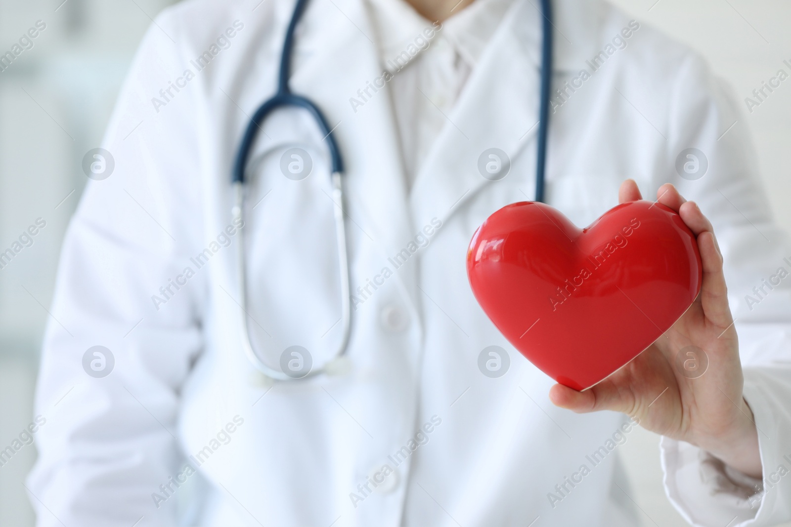 Photo of Doctor with red heart in clinic, closeup