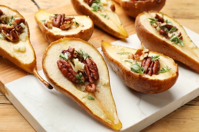 Tasty baked pears with nuts, blue cheese, thyme and honey on wooden table