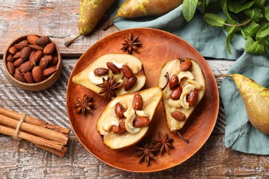 Photo of Delicious baked pears with nuts, anise stars and cinnamon sticks on wooden rustic table, flat lay