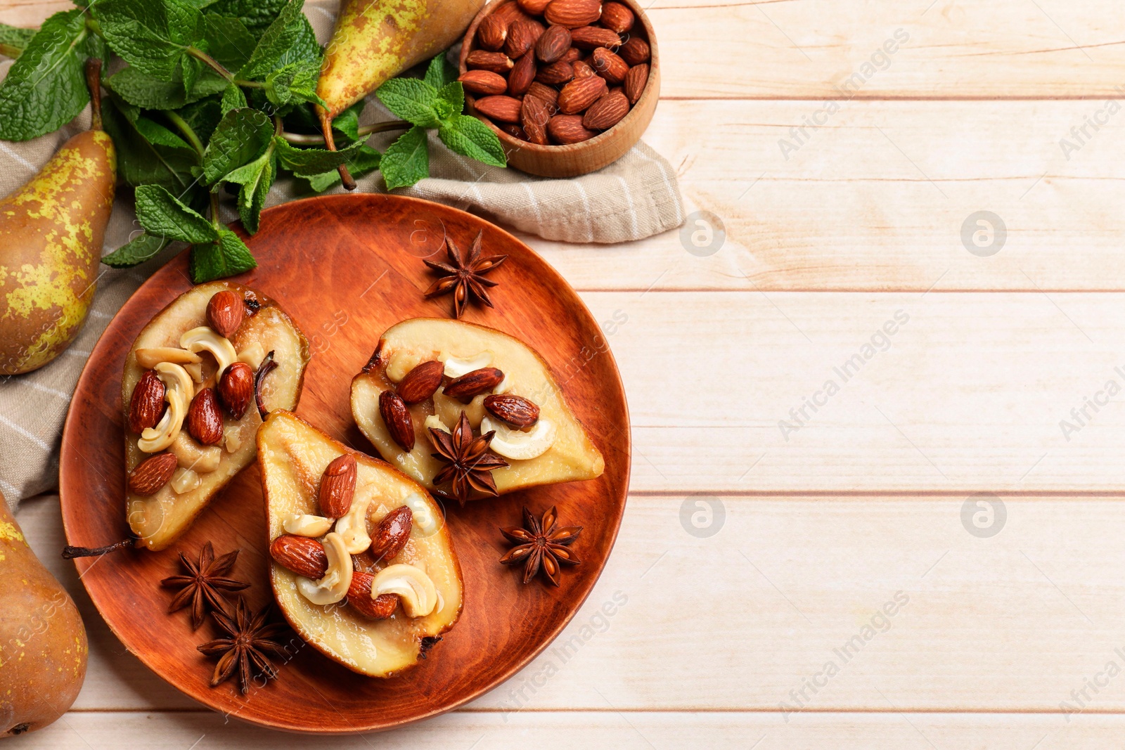 Photo of Delicious baked pears with nuts and anise stars on light wooden table, flat lay. Space for text