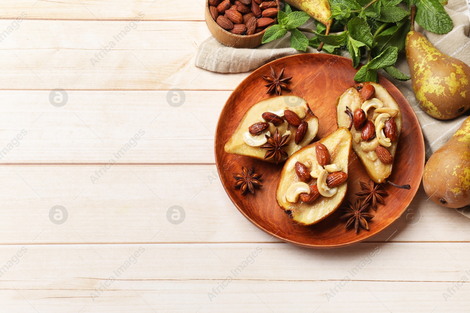 Photo of Delicious baked pears with nuts and anise stars on light wooden table, flat lay. Space for text