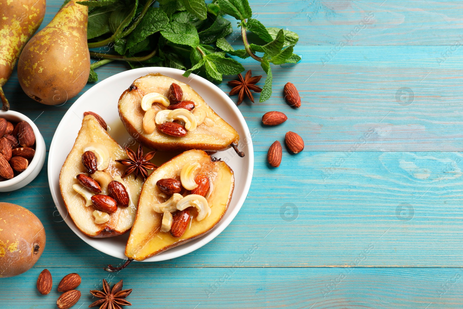 Photo of Delicious baked pears with nuts, mint and honey on light blue wooden table, flat lay. Space for text