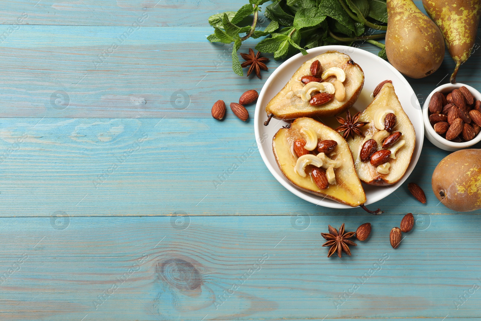 Photo of Delicious baked pears with nuts, mint and honey on light blue wooden table, flat lay. Space for text