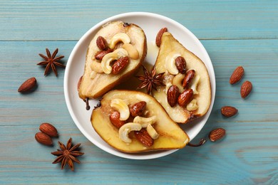 Photo of Delicious baked pears with nuts, anise stars and honey on light blue wooden table, flat lay