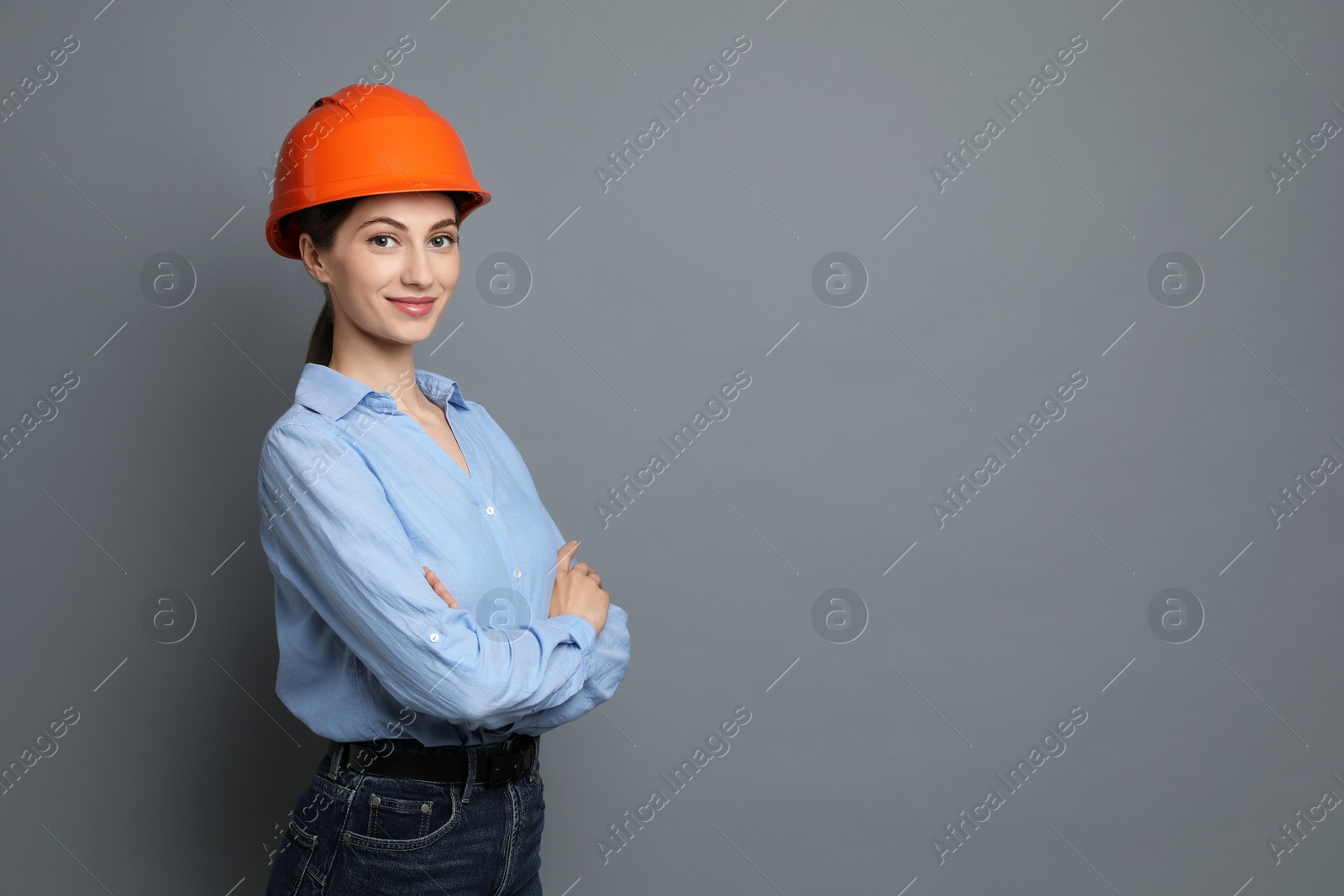 Photo of Engineer in hard hat on grey background, space for text