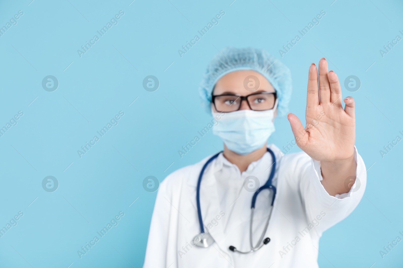 Photo of Doctor touching something on light blue background, selective focus. Space for text