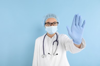 Photo of Doctor touching something on light blue background, selective focus