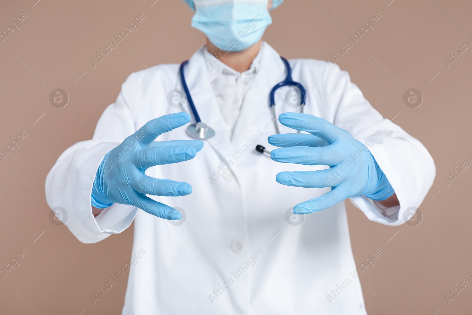 Photo of Doctor holding something on beige background, closeup