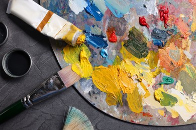 Artist's palette, brushes and paints on grey table, flat lay