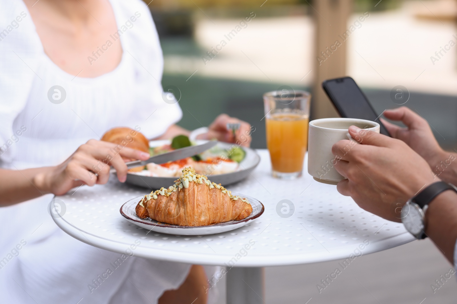 Photo of Couple having tasty breakfast in outdoor cafe, closeup