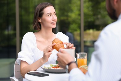 Happy couple having breakfast in outdoor cafe