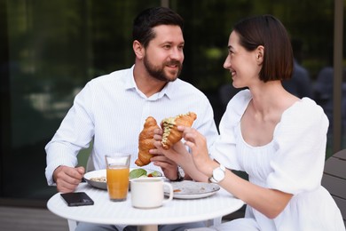 Happy couple having breakfast in outdoor cafe