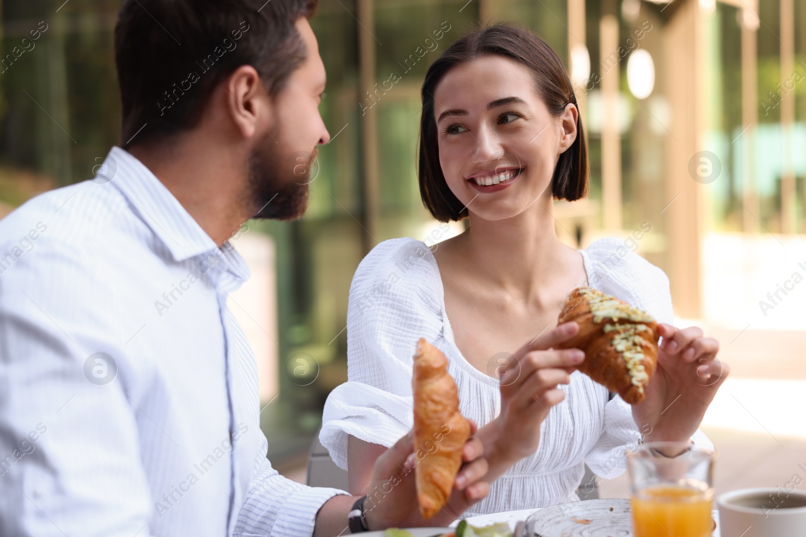 Photo of Happy couple having breakfast in outdoor cafe