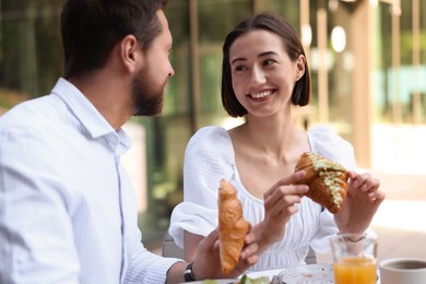 Happy couple having breakfast in outdoor cafe