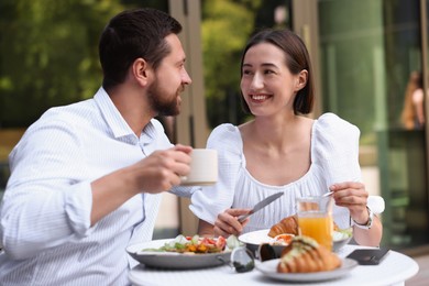 Happy couple having breakfast in outdoor cafe