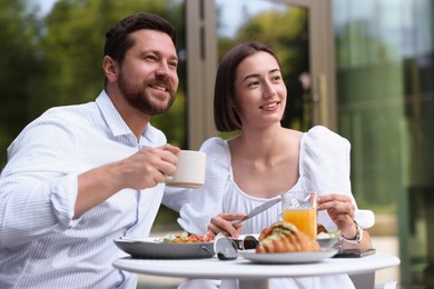 Happy couple having breakfast in outdoor cafe