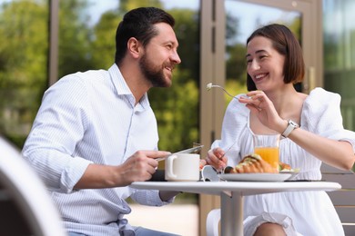 Happy couple having breakfast in outdoor cafe