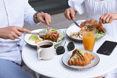 Photo of Couple having tasty breakfast in outdoor cafe, closeup