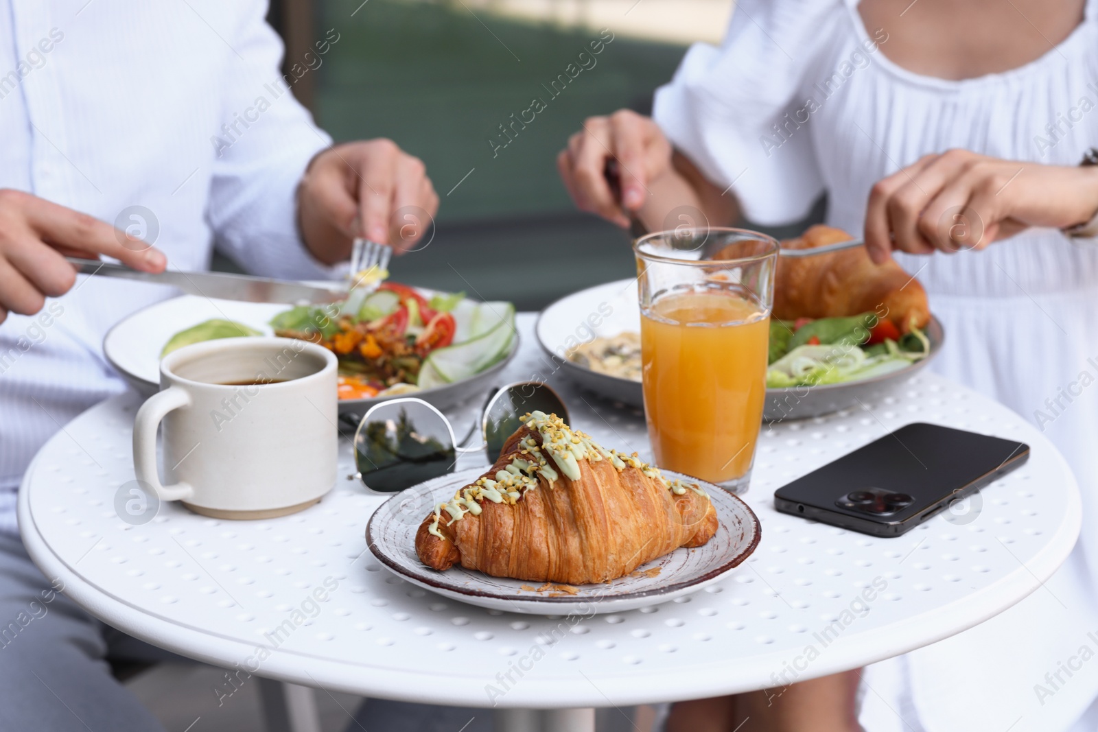 Photo of Couple having tasty breakfast in outdoor cafe, closeup