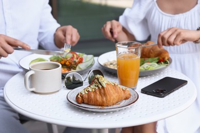 Photo of Couple having tasty breakfast in outdoor cafe, closeup