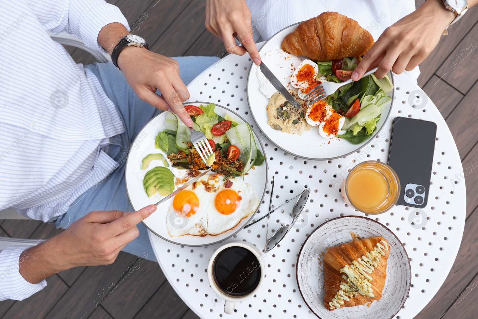 Photo of Couple having tasty breakfast in outdoor cafe, top view