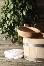 Sauna equipment. Bucket, ladle and towel on wooden surface