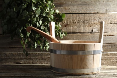 Sauna equipment. Bucket and ladle on wooden surface